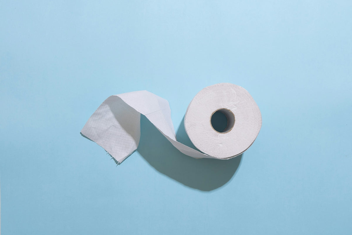 Toilettenpapierrolle vor hellblauem Hintergrund
